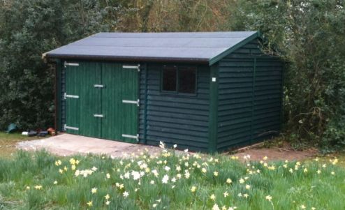 Sitting among the daffodils, this Warwick Buildings Workroom provides ideal storage for the lawn mower & other garden implements. Finished in Feather Edge Cladding & painted in Protek Spruce Green Wood Protector. Double Barn Style Doors replace the Standard Personal Door